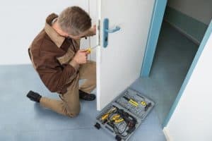 A handyman fixing basic residential door handle lock